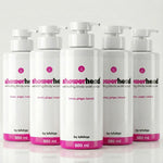 Row of white bottles with pink labels on a light gray background